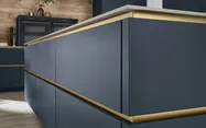Detailansicht der Grifflos-Küche in blau mit goldenen Griffleisten