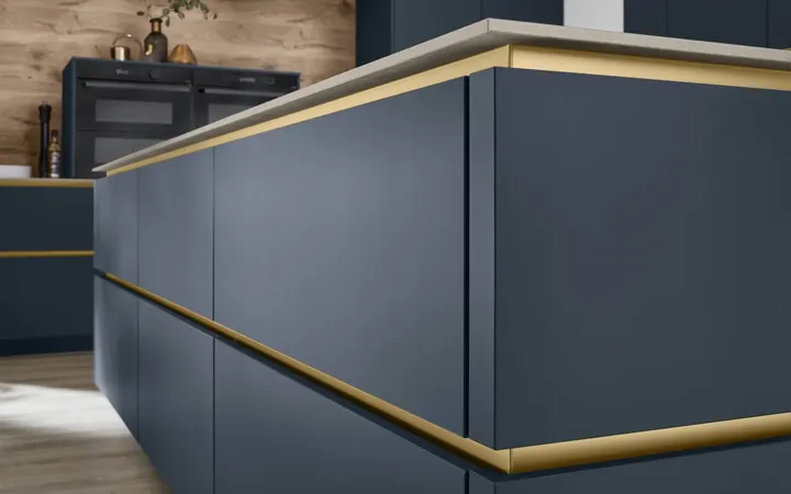 Detailansicht der Grifflos-Küche in blau mit goldenen Griffleisten